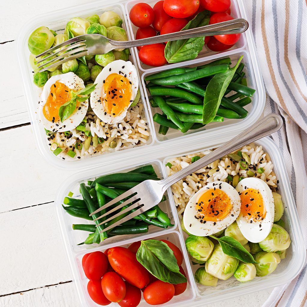 Vegetarische Meal-Prep-Boxen mit Eiern, Rosenkohl, grünen Bohnen und Tomaten. Abendessen in der Lunchbox. Draufsicht. Flache Anordnung.